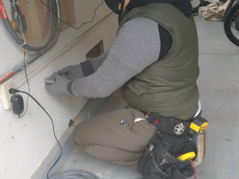 Electrician performing outlet wiring in a East Goshen garage
